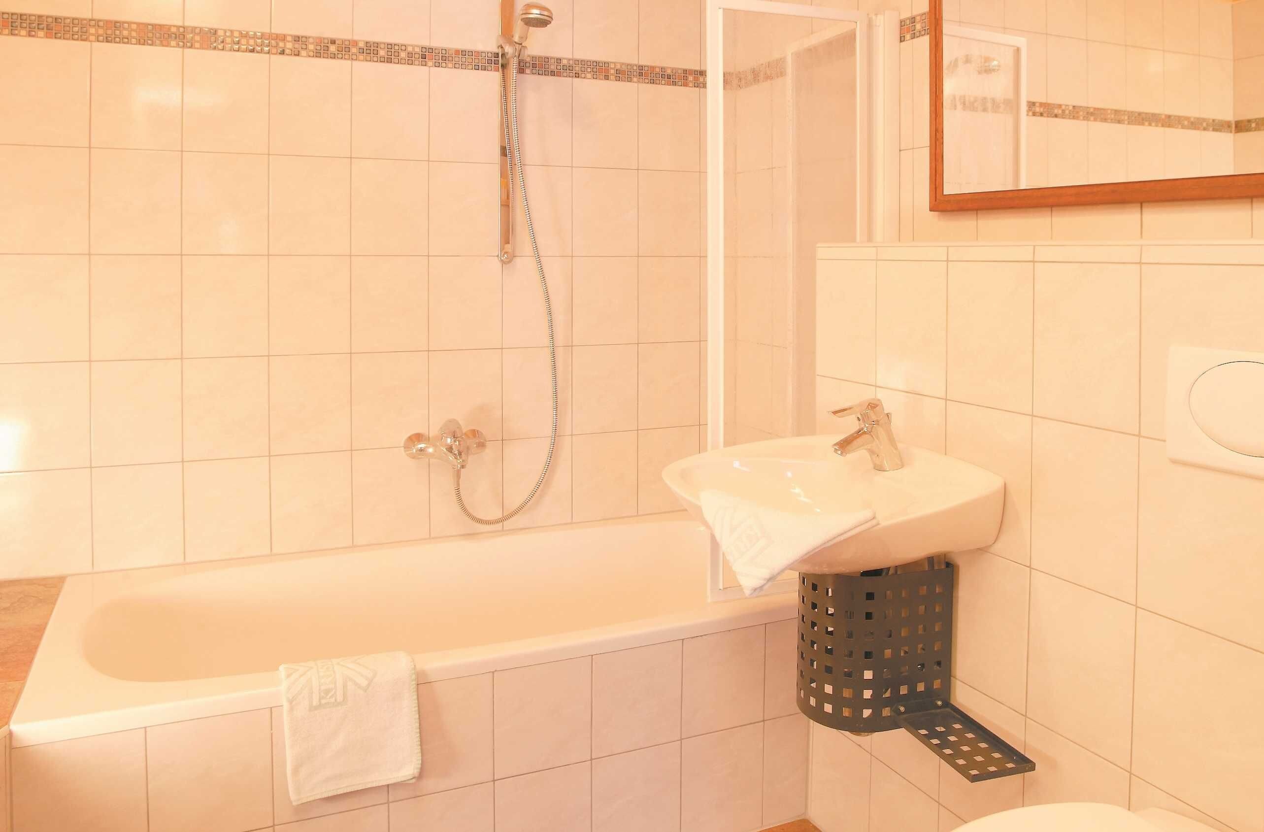 Een badkamer met een bad, een wastafel en een douche.