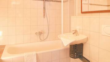Een badkamer met een bad, een wastafel en een douche.