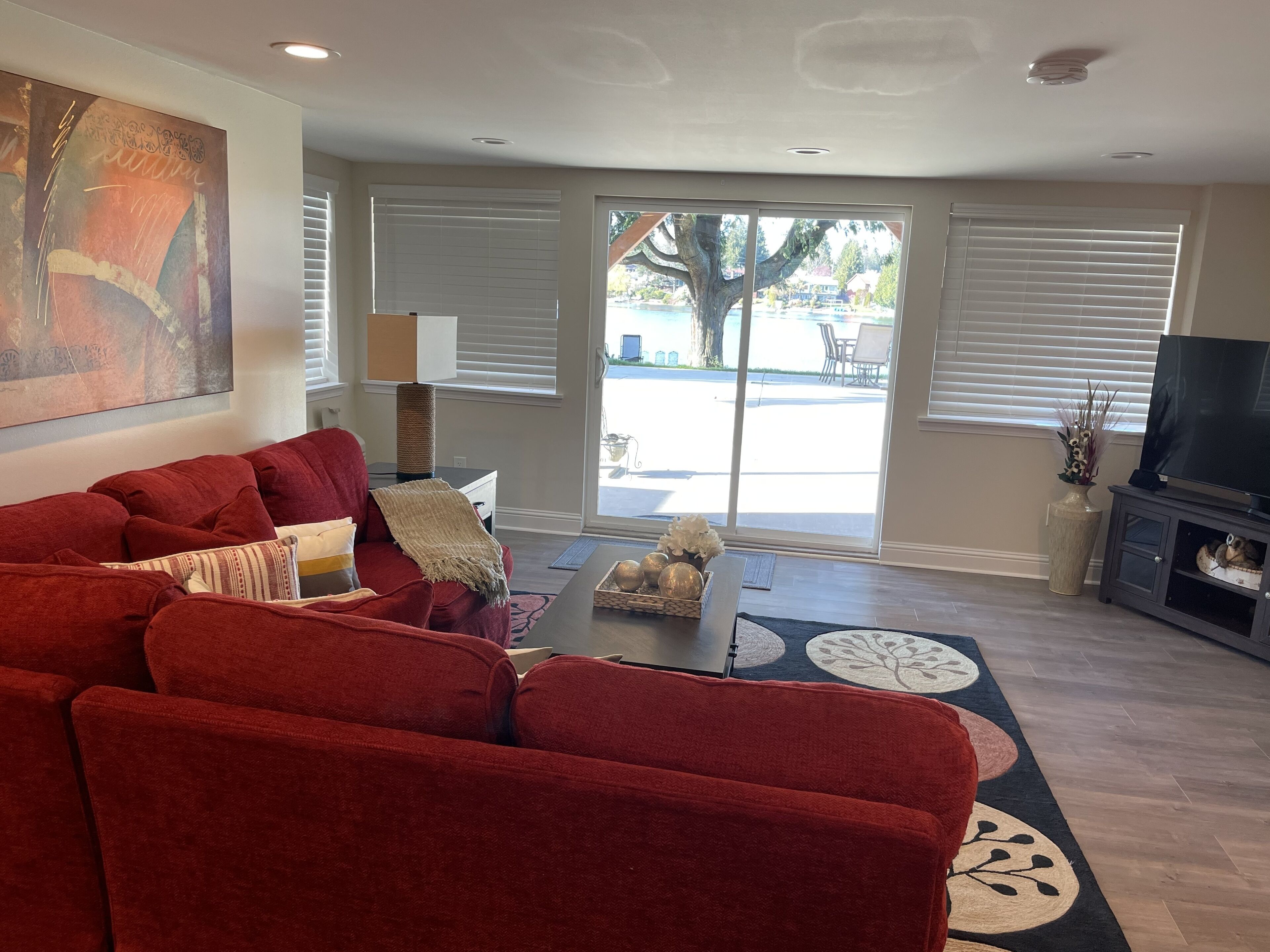 A living room with a red sofa, a coffee table, and a TV stand.