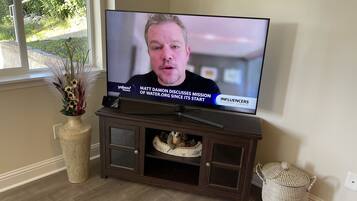 A television on a wooden stand displaying a news program.