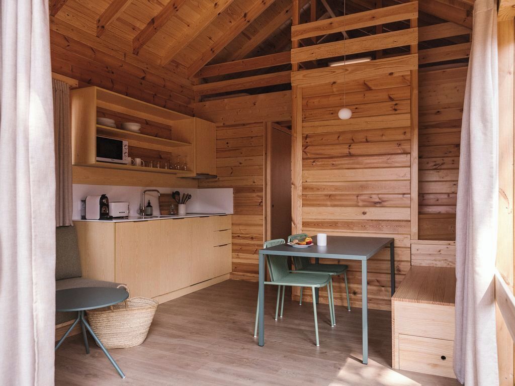 Una cocina compacta con paredes de madera y una zona de comedor.
