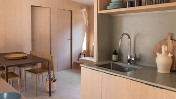 Una cocina moderna con armarios de madera, un lavamanos y un comedor con mesa y sillas.