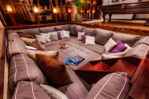 A corner seating area with cushioned sofas, a coffee table, and a book.
