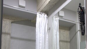 Une salle de bain avec douche, toilettes et lavabo.