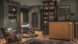 Una sala de estar moderna con una mesa de centro de madera, un sillón cómodo, una estantería y un espejo decorativo.