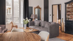 Una sala de estar moderna con un sofá gris, una mesa de centro de madera y una lámpara.