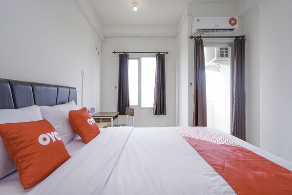 A hotel room with a bed, a desk, and a chair.