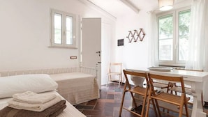 A bedroom with a bed, a chair, a table, and a window. - Villa LA CASETTA for 4-6 persons - with jacuzi (San Felice Circeo)