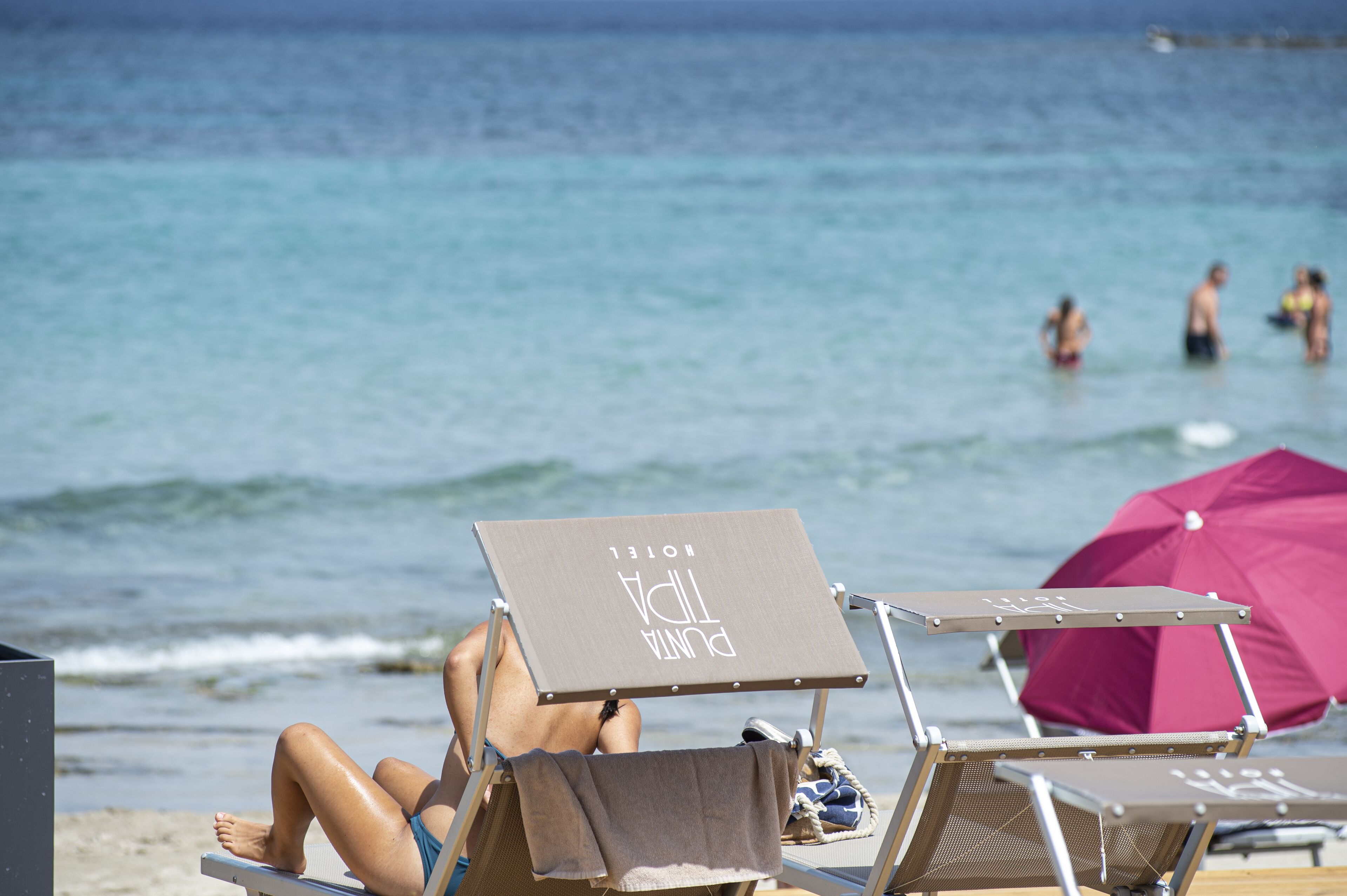 A beach chair with a towel and a sign that reads "PUNTA HOTEL".