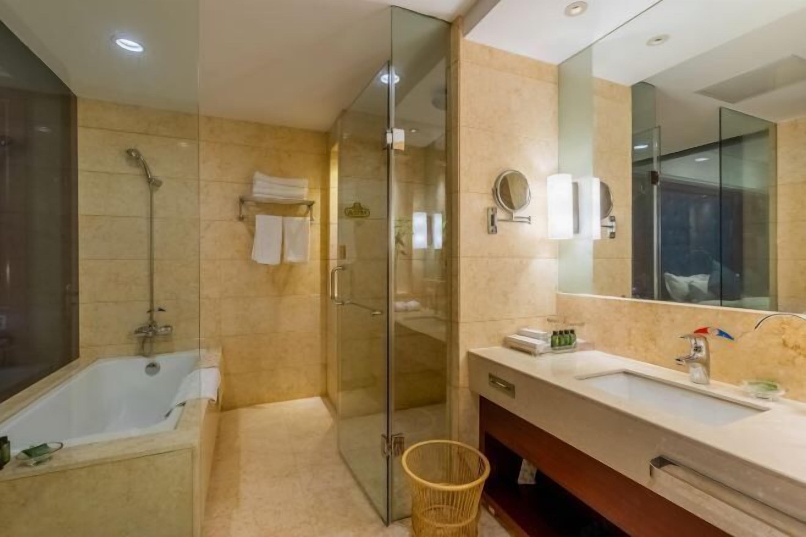 Une salle de bain moderne avec une douche à parois de verre, une baignoire, un meuble-lavabo avec un miroir et un panier en osier.
