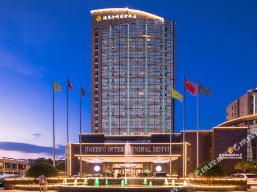 Un hotel moderno y alto con una entrada destacada y varias banderas.