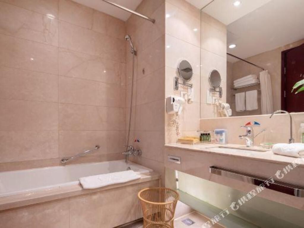 A modern bathroom with a bathtub, a shower, a vanity with a mirror, and a towel rack.