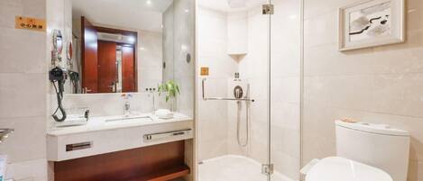 A modern bathroom with a glass-enclosed shower, a sink with a mirror, and a toilet.