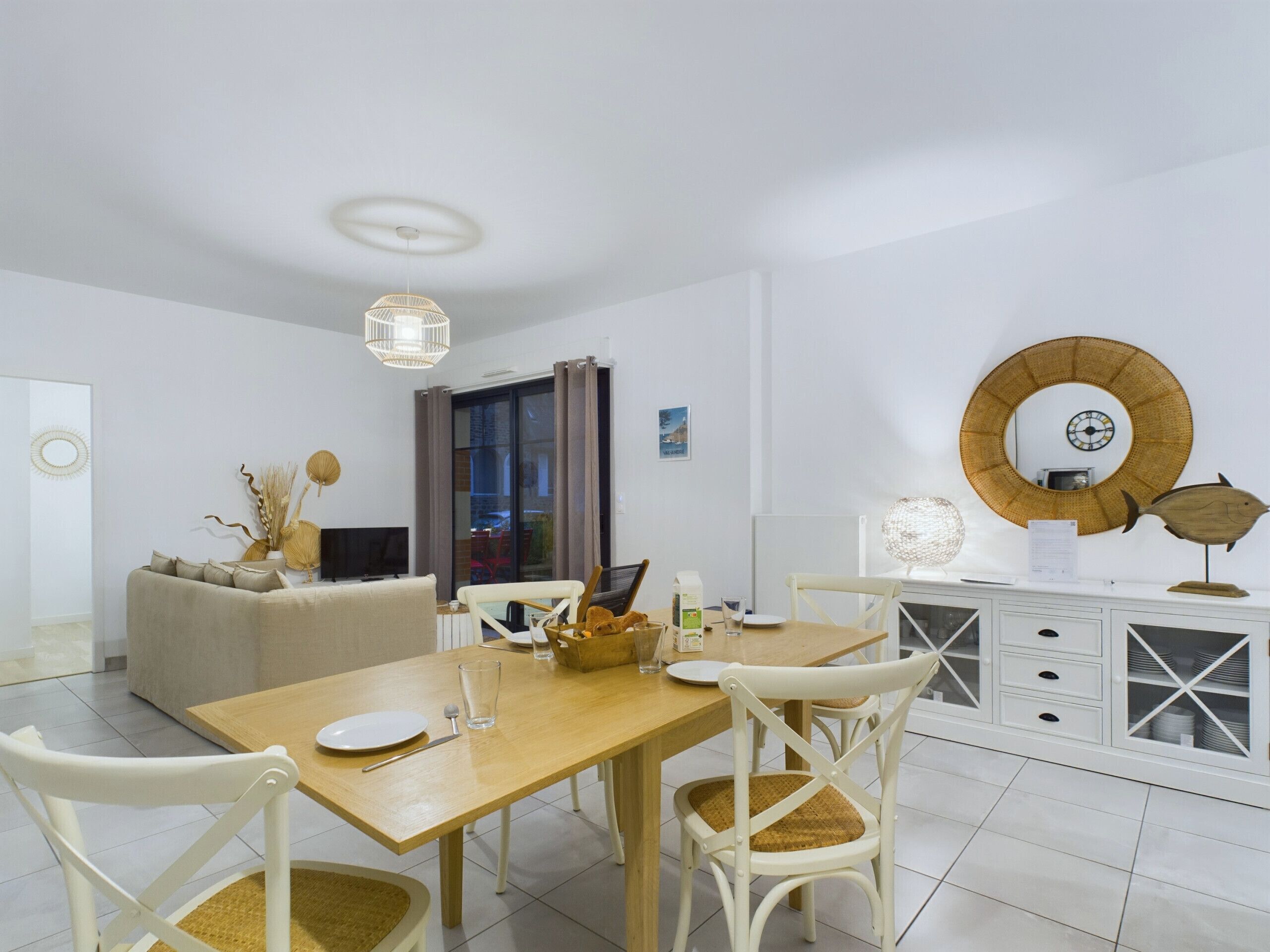 A modern dining area with a wooden table, white chairs, and a white cabinet with glass doors.