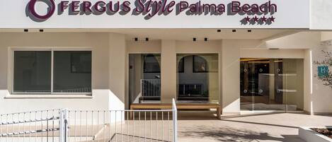 Un edificio con un letrero que dice 'Fergus Style Palma Beach' y una escalera que conduce a la entrada.