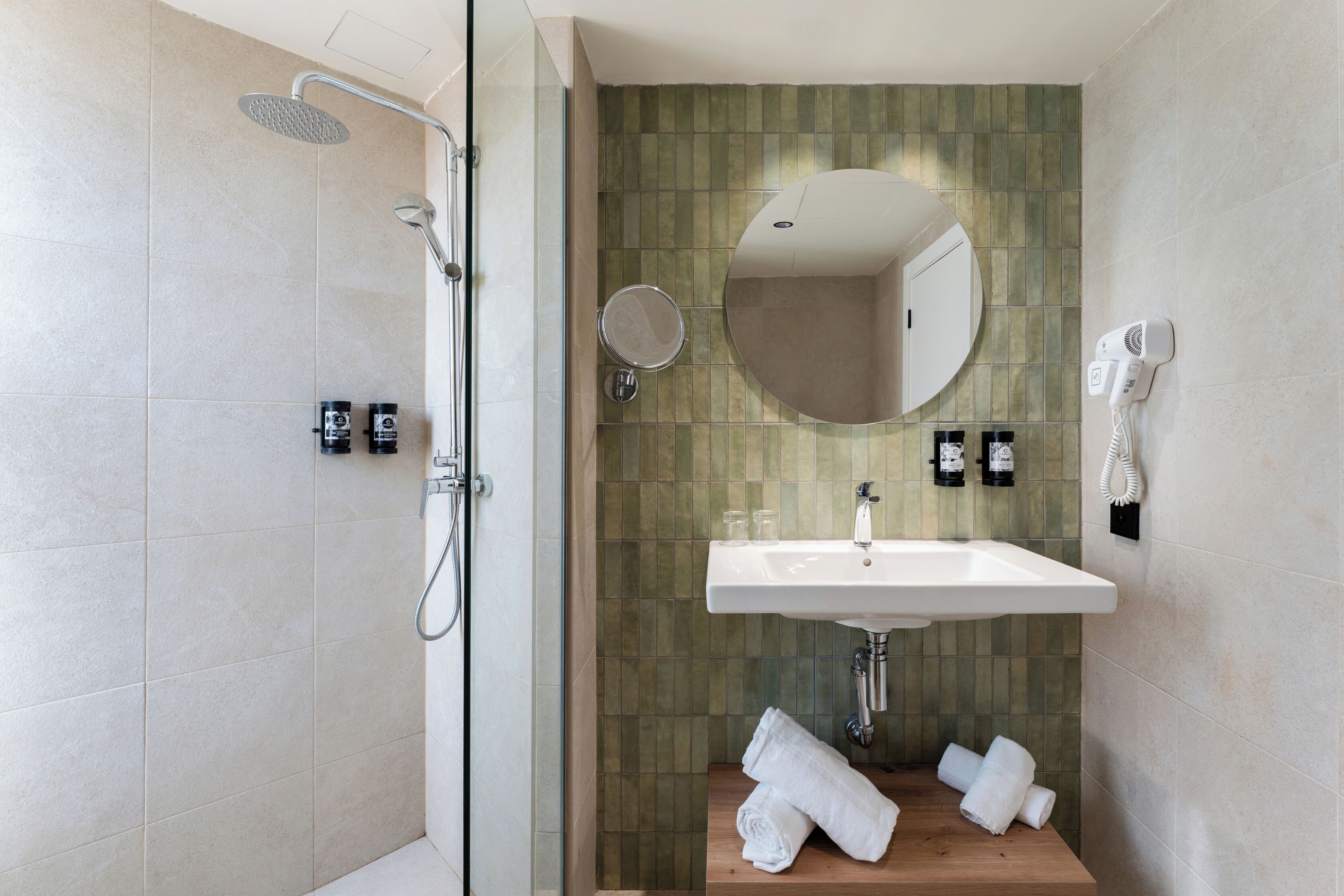 Un baño moderno con ducha, lavamanos y espejo.