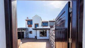Et moderne hus med terrasse, garage og stenvæg.