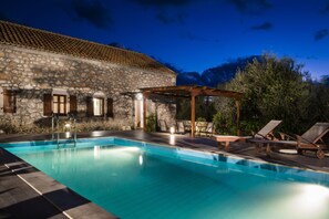 A stone building with a swimming pool, outdoor seating, and a pergola. - 1841 Petrino (Kefalonia)