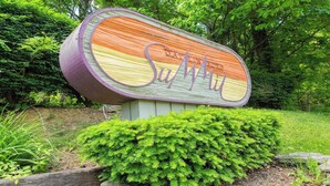 A sign with the text "SOUTHWIND" in a stylized font, surrounded by greenery.