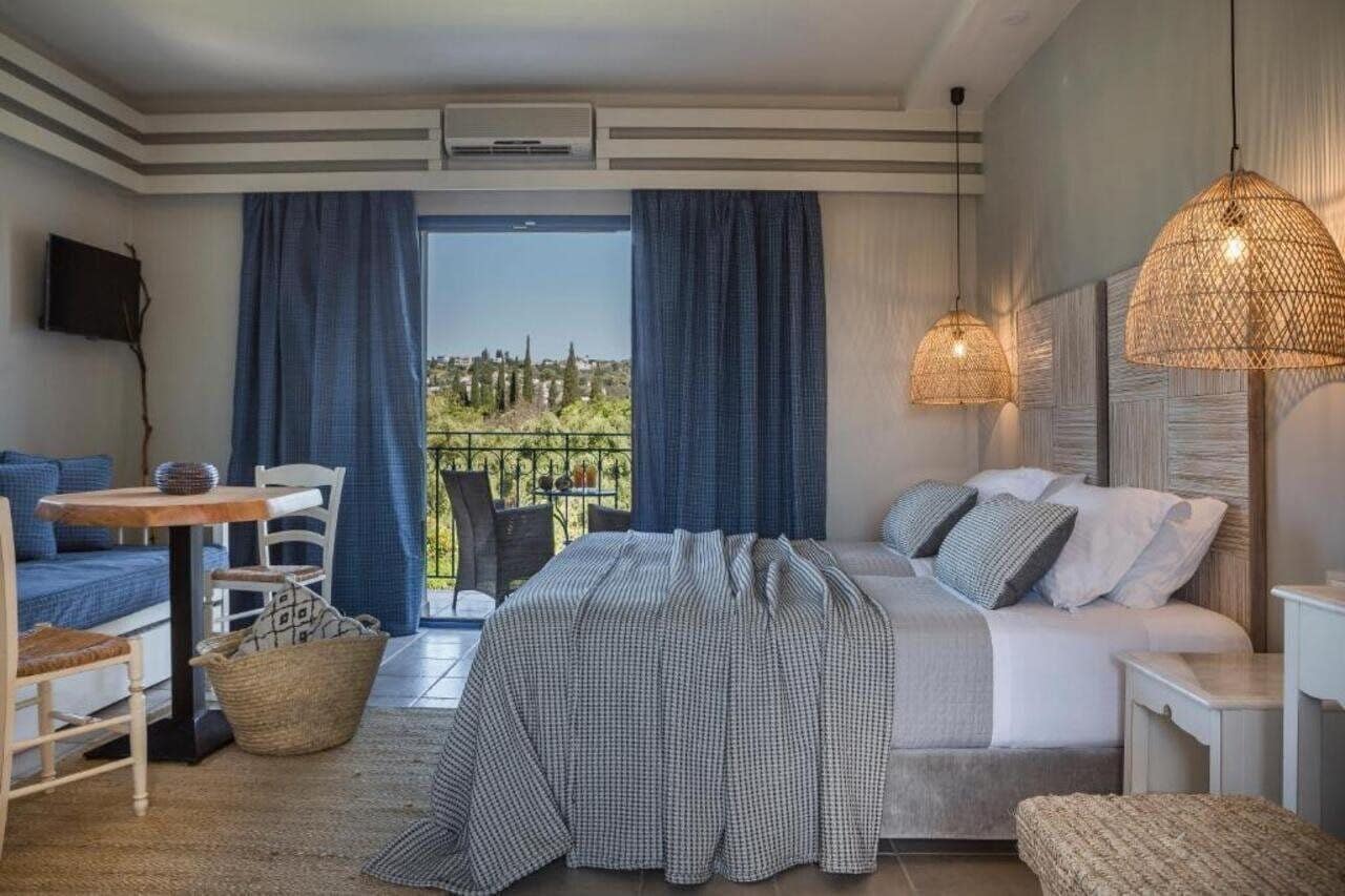 A bedroom with a bed, a sofa, a table, and a TV.
