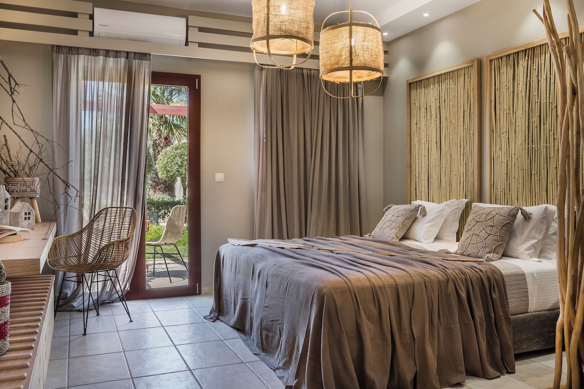 A bedroom with a bed, a chair, a window, and curtains.