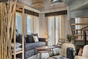 Una sala de estar moderna con un sofá, sillas, una mesa de centro y una escalera.