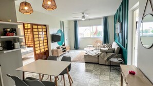 Un saló modern amb zona de menjador, seients de sofà i cuina visible al fons.