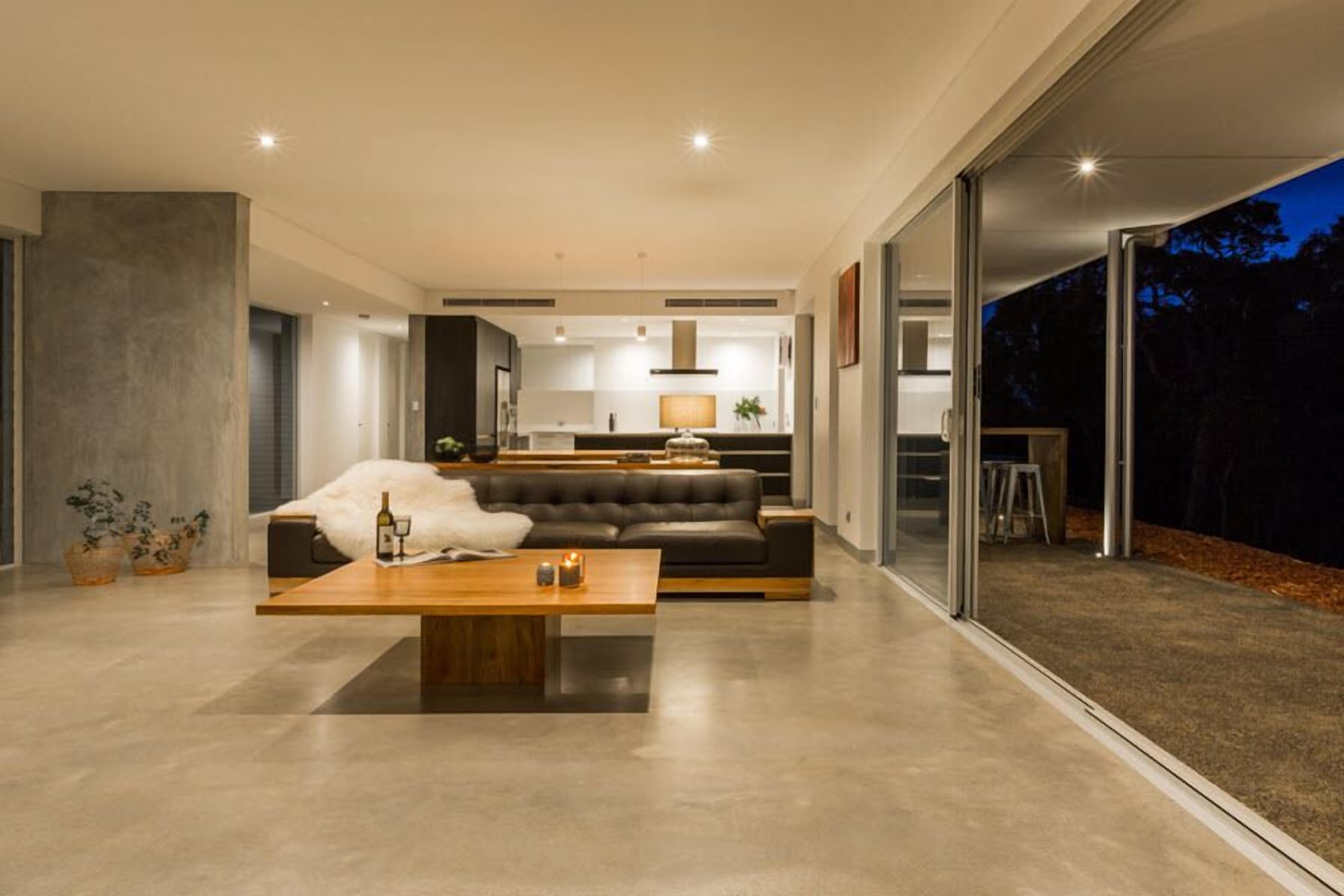 Un moderno salón con sofá, mesa de centro y vistas al exterior.