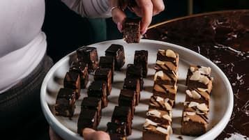 A person holding a plate with various chocolate bars.