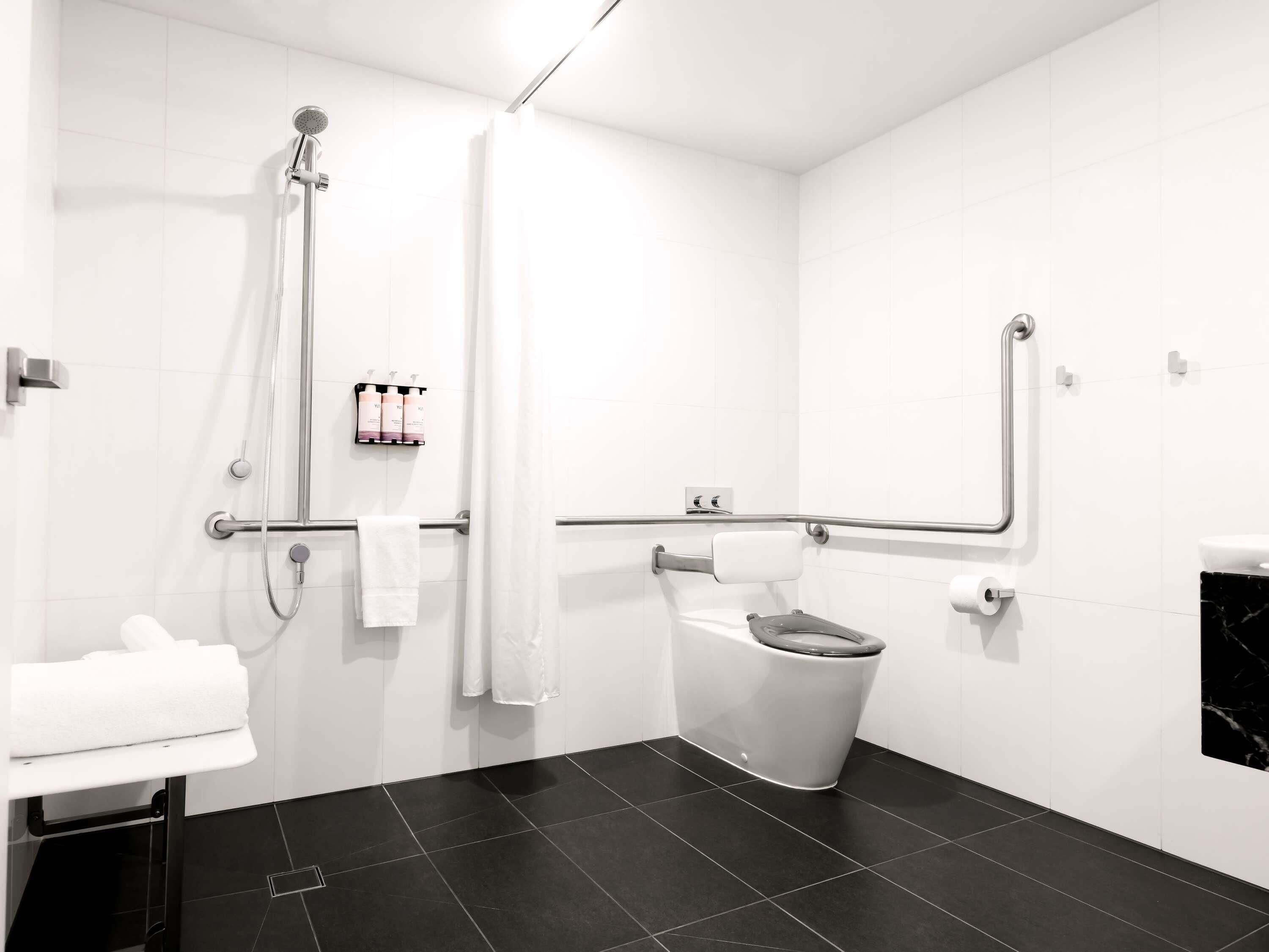 Une salle de bain moderne équipée d’une douche, de toilettes et d’un lavabo.