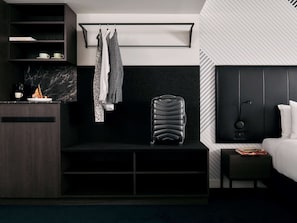 Relax in a stylish room with a wardrobe, seating area, and large window offering a view of the outside.