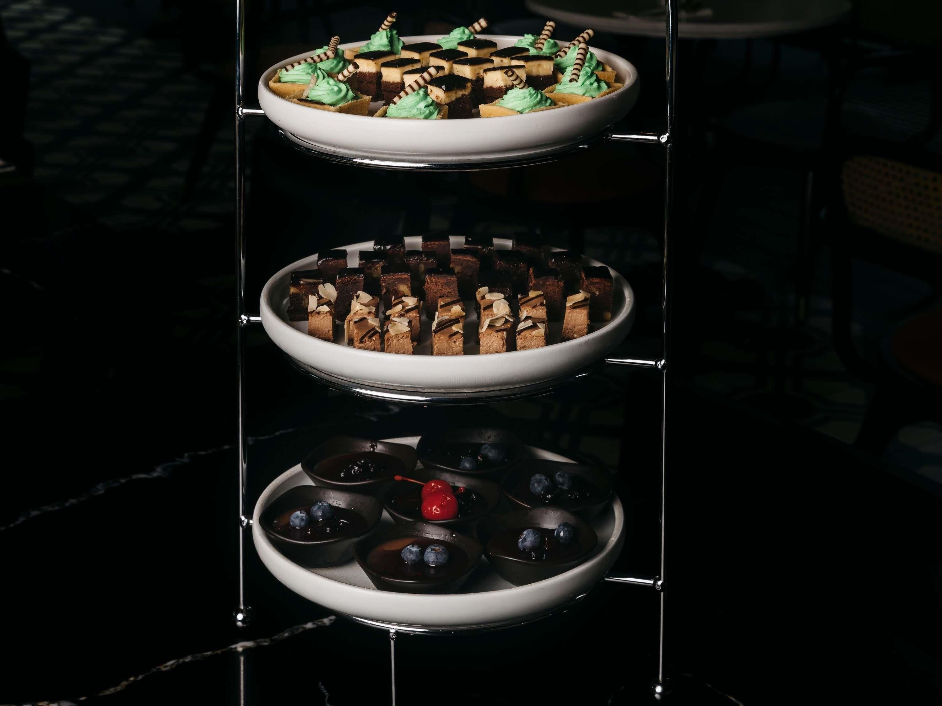 Una presentación de postres con múltiples bandejas de dulces variados.