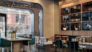 Un interior moderno con una zona de bar, asientos y obras de arte en las paredes.