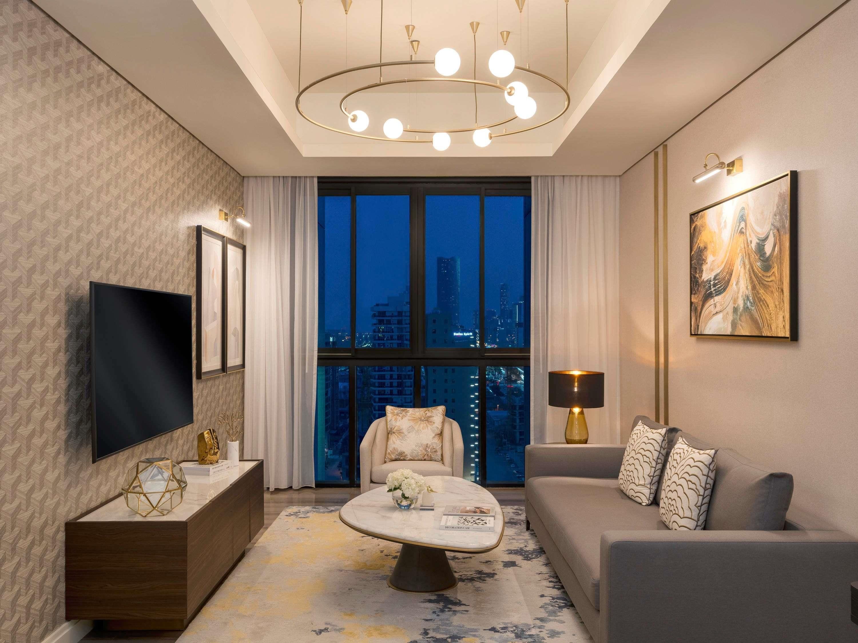 A modern living room with a TV, sofa, and a large window with a city view.
