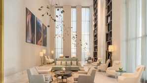 A spacious living area with a sofa, armchairs, a coffee table, and a bookshelf. - Fairmont Ramla Riyadh (Riyadh)