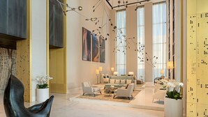 Eine geräumige Lobby mit modernem Design, ausgestattet mit einer großzügigen Sitzecke, einer markanten schwarzen Skulptur und großen Fenstern für viel Tageslicht.