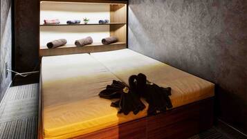 Quarto moderno com cama, estantes embutidas e relógio na parede.
