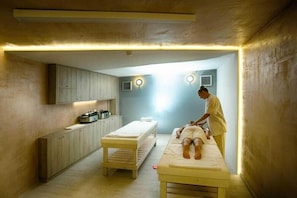 A room with a massage table, a bench, and a cabinet with appliances. - Ida Village Apartments I and II (Hersonissos)