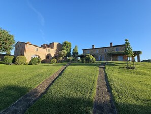 A large stone building with a grassy lawn and a paved path leading to it.