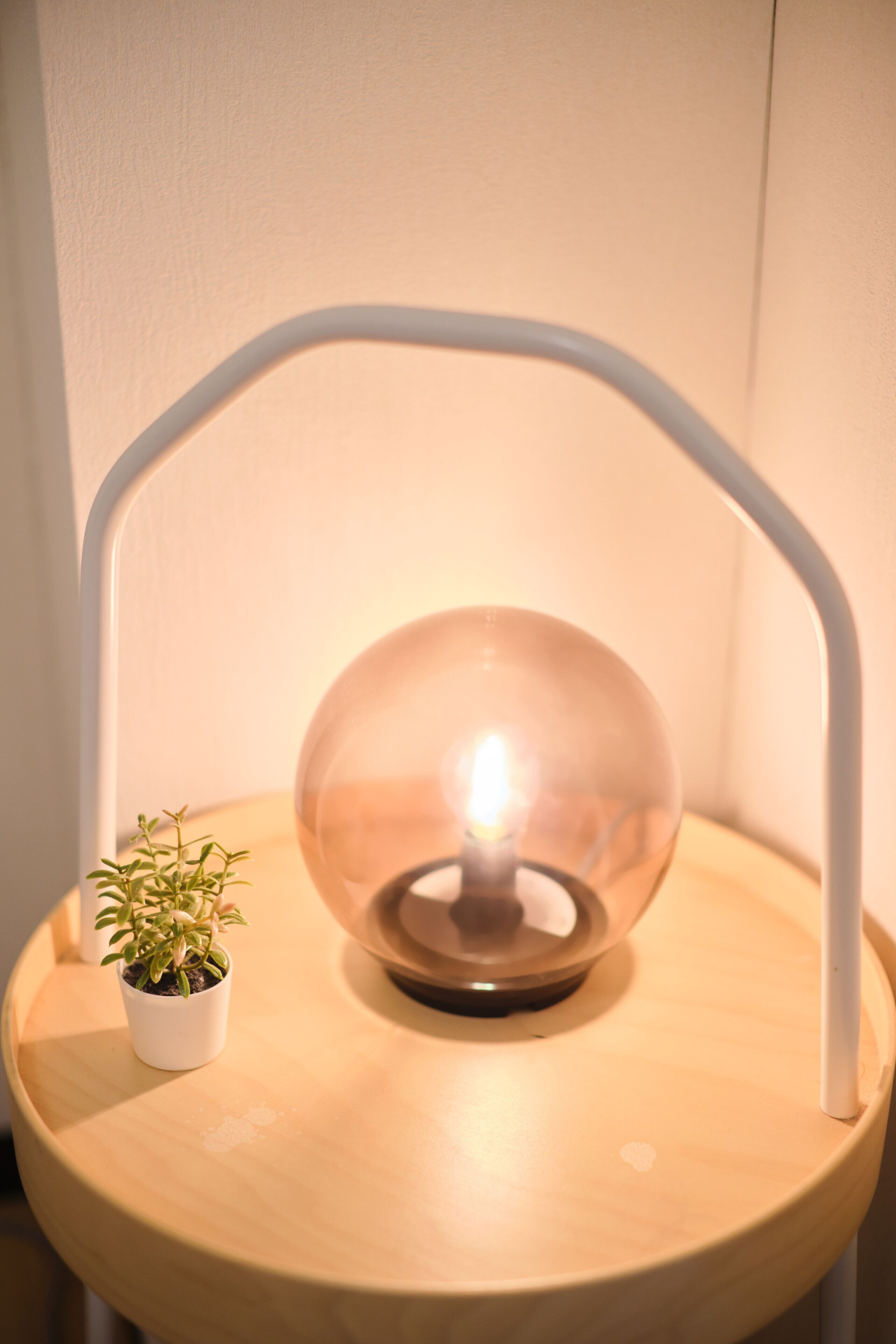 A lamp with a clear glass shade on a wooden table.