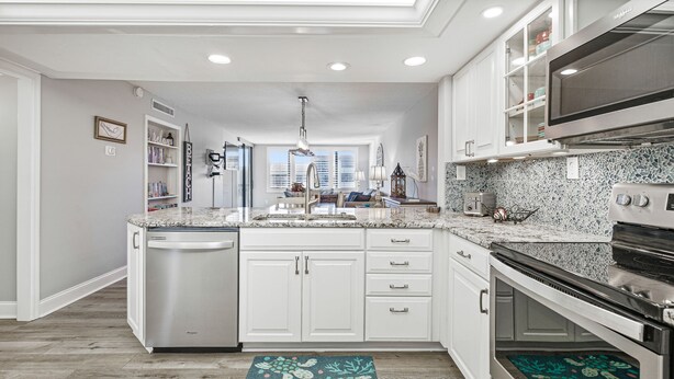 A modern kitchen with white cabinetry, a built-in dishwasher, and a large island with a sink. - 🌺Remodeled Coastal Retreat With Beach Gear 🐶 Loggerhead Cay 463🐠 (Sanibel)