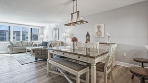 A spacious living room with a dining area, large windows, and a chandelier. - 🌺Remodeled Coastal Retreat With Beach Gear 🐶 Loggerhead Cay 463🐠 (Sanibel)