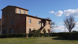Un edificio de ladrillo de dos plantas, con varias ventanas y una escalera.