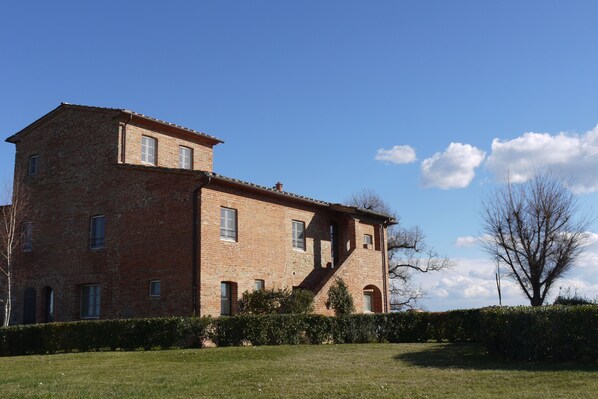 Un edificio in mattoni di due piani con diverse finestre e una scala.