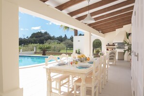 A dining area with a view of a swimming pool and garden. - Modern Finca Batlet, phantastic pool and barbecue area in a quiet location, A/C (Calonge)