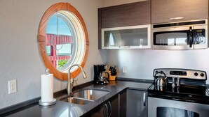 A modern kitchen with a stainless steel sink, a kettle, a coffee maker, and a microwave. - 3-Bedroom, 2.5-Bathroom Suite at REAL Watersports (Waves)