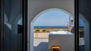 Un interior moderno con vista al mar a través de un ventanal arqueado.