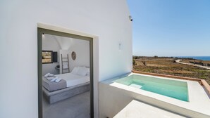 Un dormitorio moderno con vistas al mar, un jacuzzi privado y un balcón.