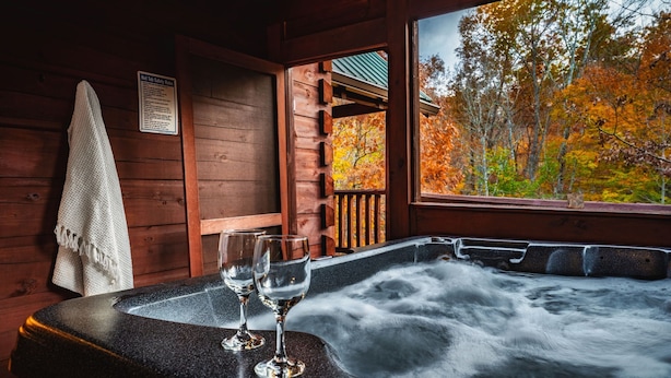 A wooden cabin with a hot tub, two glasses, and a towel on a wall. - 2Kings!Jacuzzi*Fireplace*Pool*Pets ok (Sevierville)
