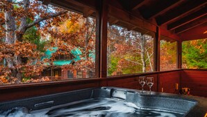 A hot tub with a view of autumn trees and a building outside. - 2Kings!Jacuzzi*Fireplace*Pool*Pets ok (Sevierville)